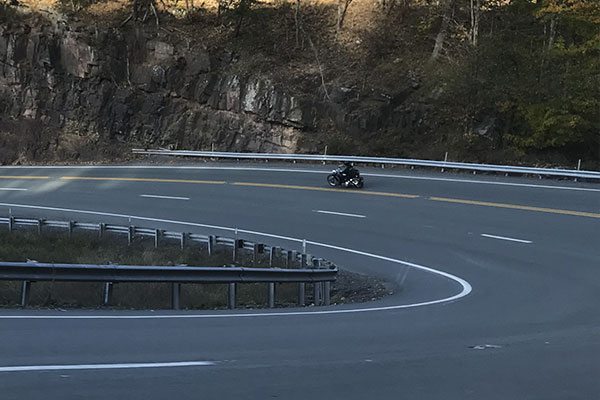 A motorcyclist driving down a road in West Virginia