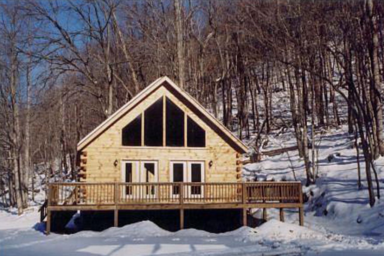 Exterior view of log cabin surrounded by snow-covered ground
