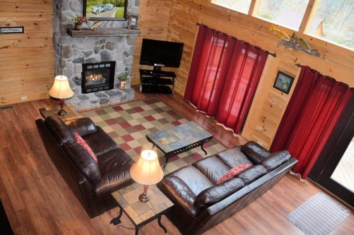 Aerial view of living area with sofas, television, stone fireplace, and other furnishings
