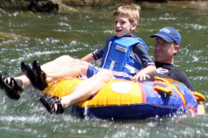 A father and son tubing down a river
