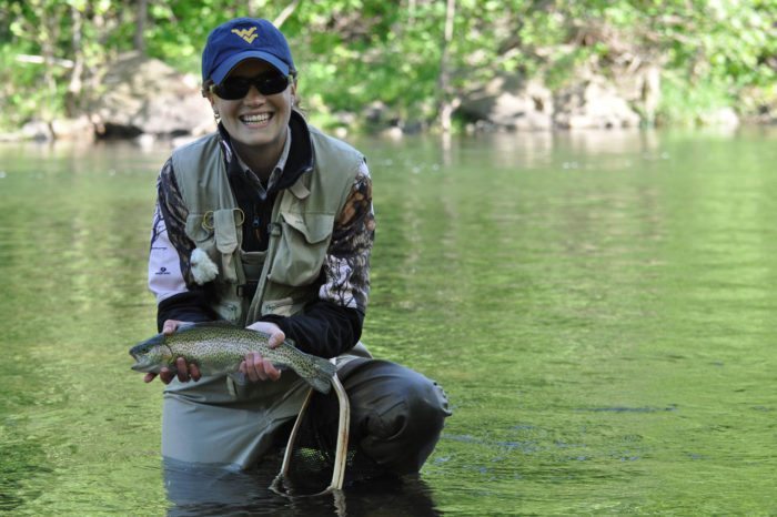 smiling woman holding a trout