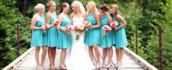 A bride with her bridesmaids standing on a bridge
