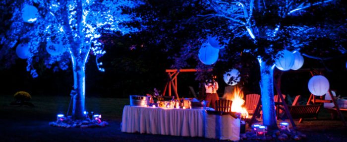 An outdoor wedding reception at night with warm and cold colors