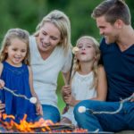 a family roasting marshmallows around the campfire