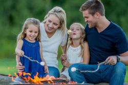 a family roasting marshmallows around the campfire