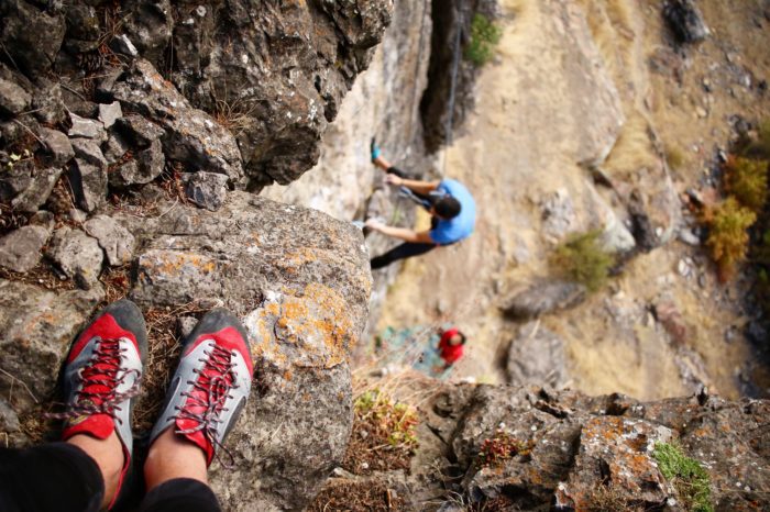 Rock climbers climbing up a rock face.