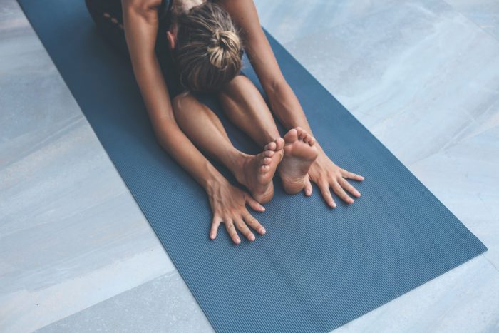woman performing yoga on a yoga mat