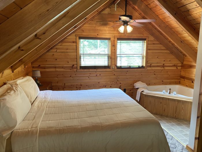 Bedroom with a jacuzzi tub in a West Virginia cabin rental at Harman's Log Cabins.