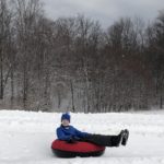 Young boy snow tubing in West Virginia.