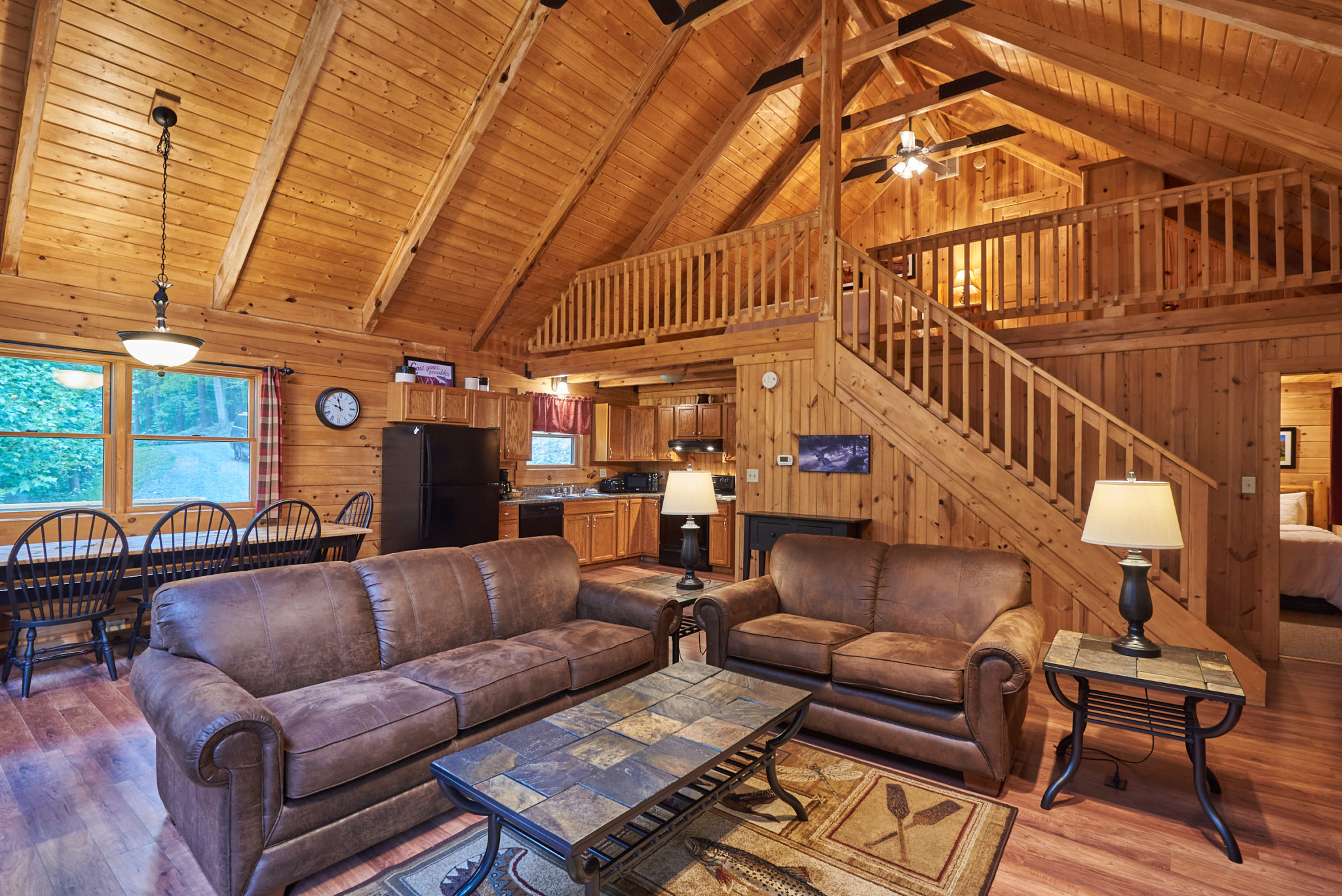 Living room, kitchen, and loft in Harman's Fly Rod Chronicles West Virginia cabin rental.