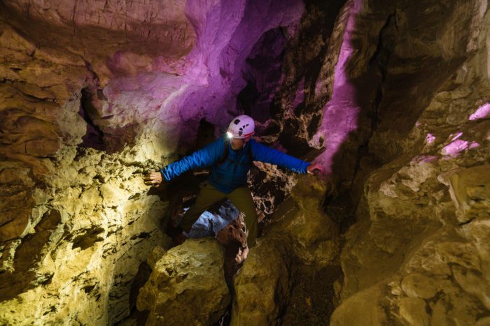 A man caving and wearing caving gear.