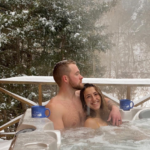 Romantic couple spending time in the outdoor private hot tub at one of Harman's West Virginia cabin rentals.